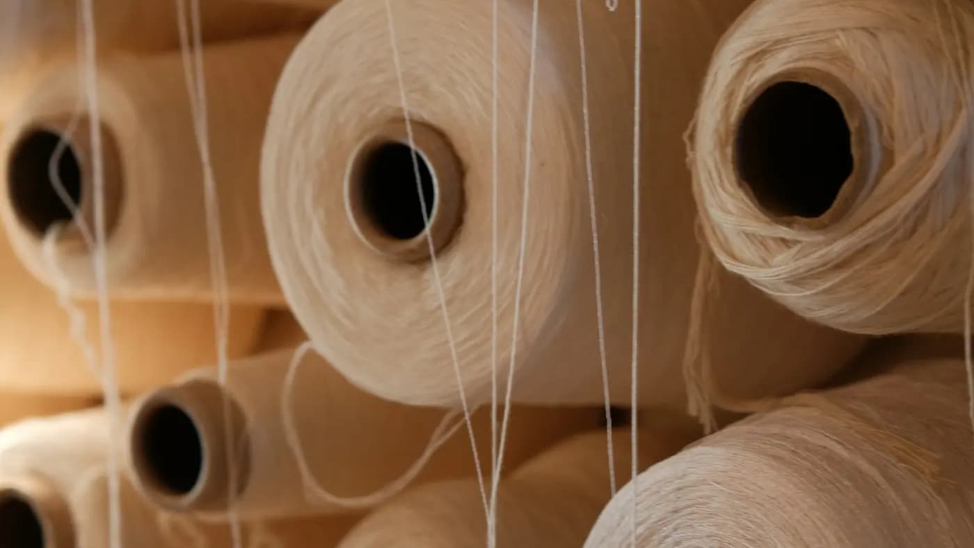 Cones of undyed natural thread standing in a spinning mill