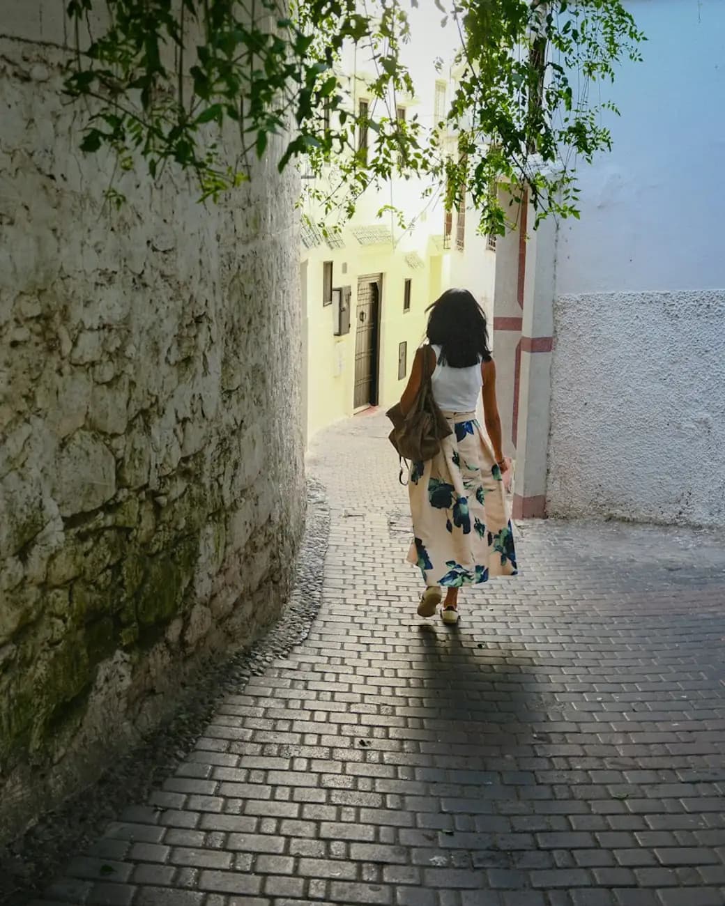 A shopper walking down a sunlit lane in the neighbourhood