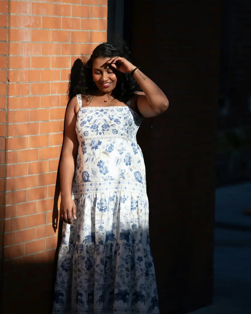 A summer dress from the new rail, worn against a brick wall
